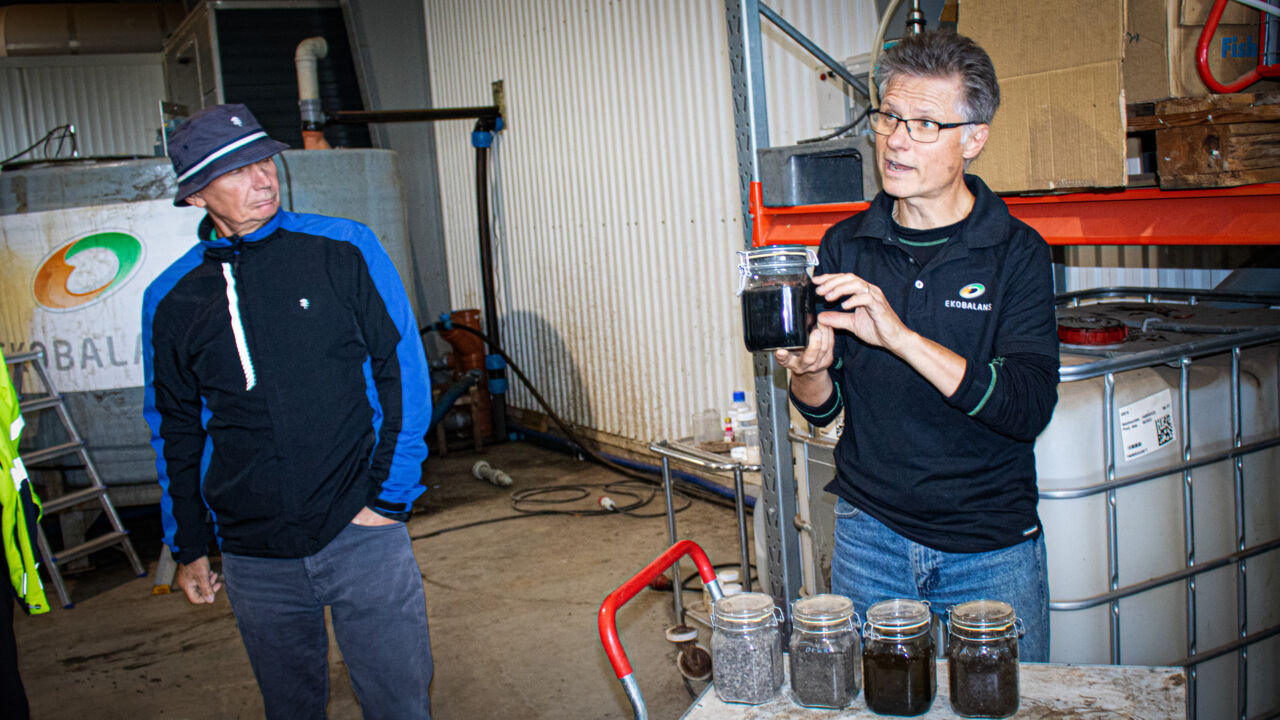 Två män föreläser i fabrikslokal.