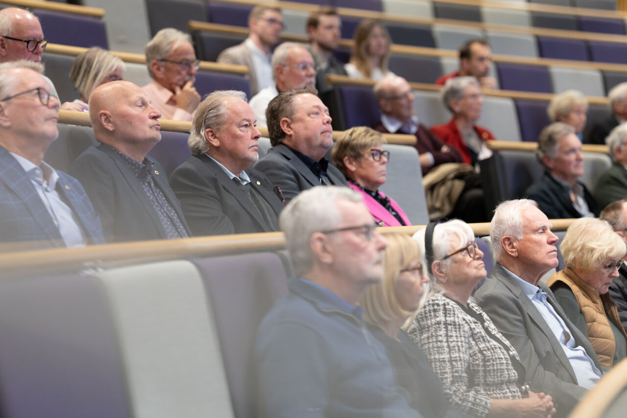 Personer sitter i föreläsningssal och lyssnar