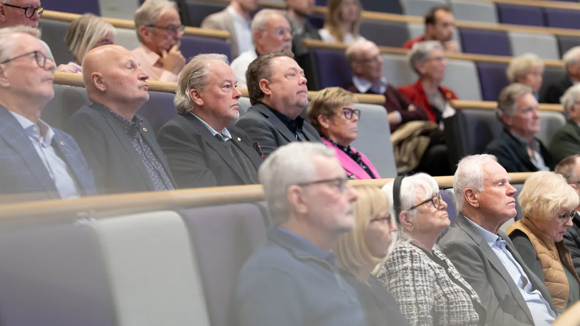 Personer sitter i föreläsningssal och lyssnar