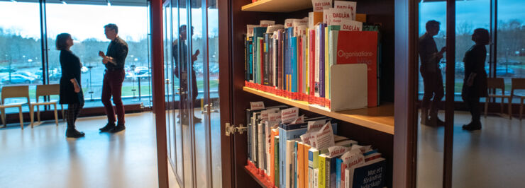 Bokhyllor och två personer som pratar i bakgrunden