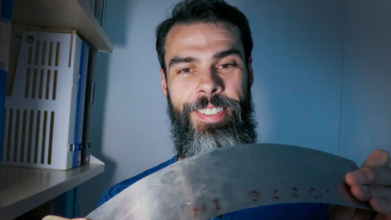 Manlig professor visar olika mekaniska brott på metallföremål.