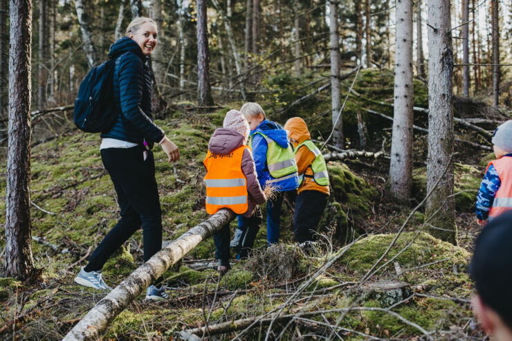 En grupp barn med sin lärare i skogen.