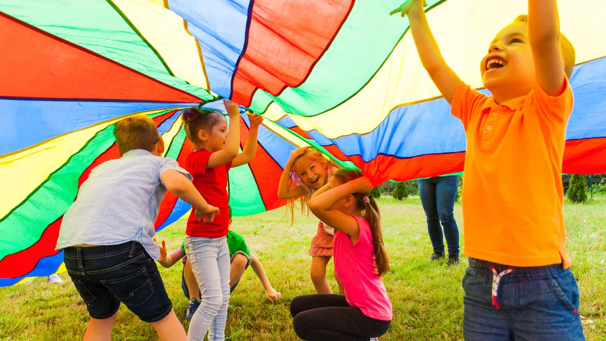 Barn leker med en stor fallskärm.