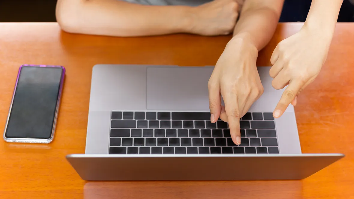 Hands pointing at a laptop.