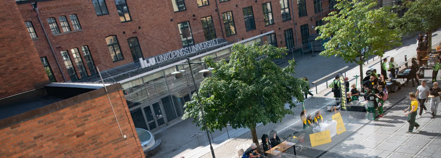 Överblick över mottagningsaktiviteter på universitetet, med studenter som går och står i olika grupper