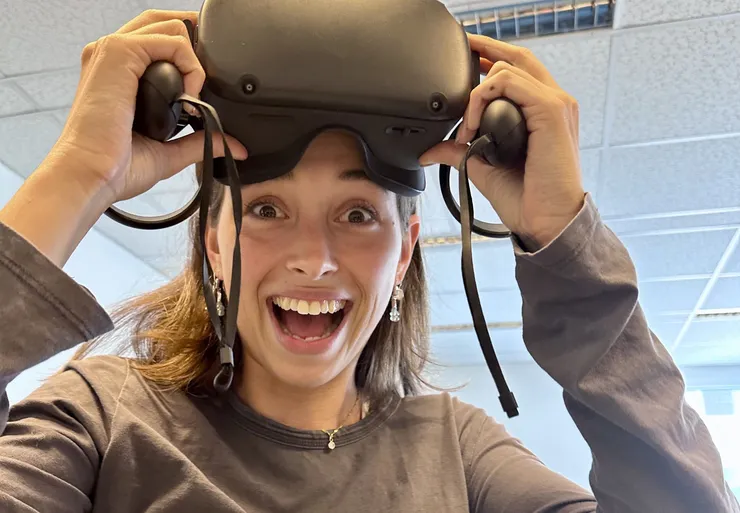 A happy woman wearing VR goggles