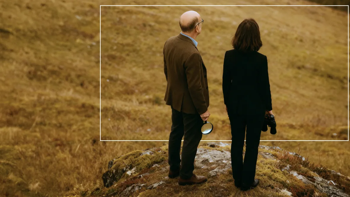 Två personer tittar ut över ett Skandinaviskt landskap.