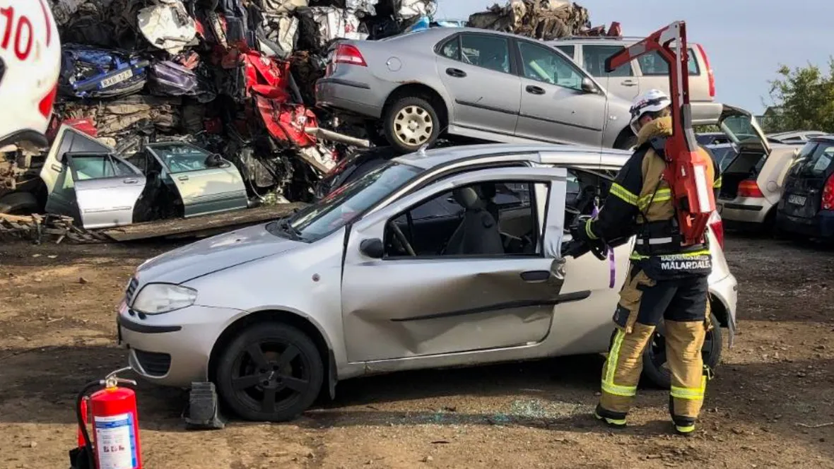 Brandman framför bilvrak.