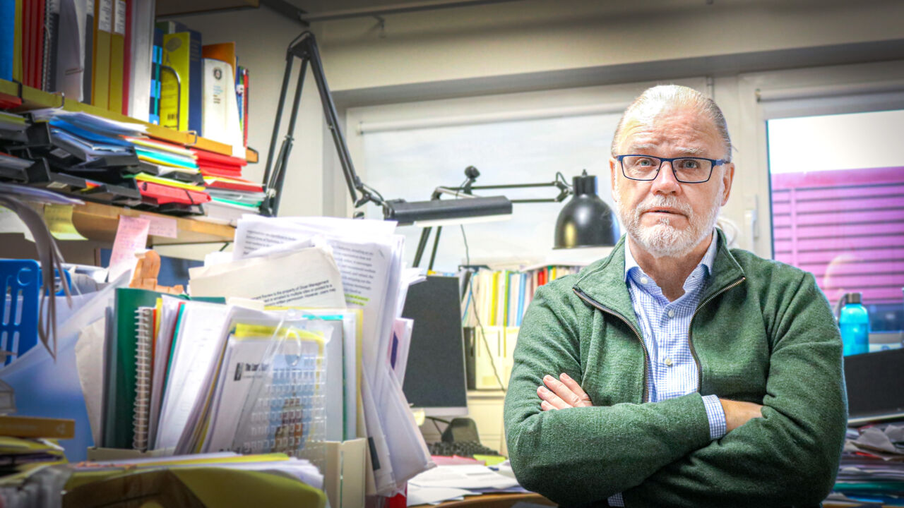 Manlig forskare i kontor med mycket böcker.