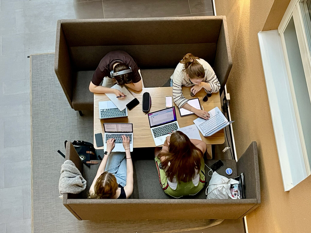 Studenter som sitter runt ett bord och pluggar