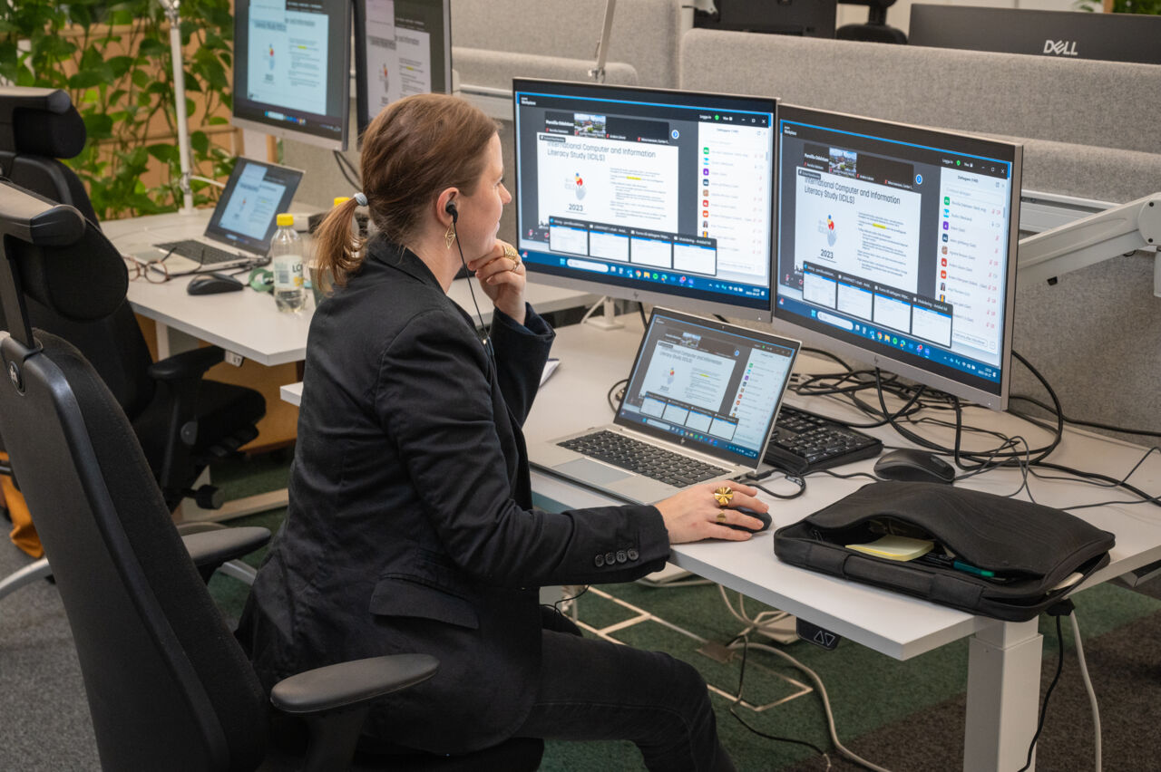 Konferensens samordnare framför datorskärmar.