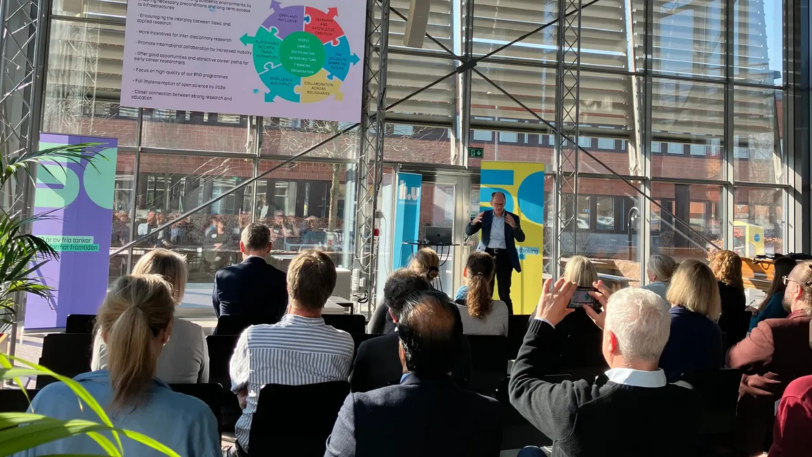 En man på scen talar inför publik