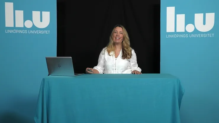 Forskare håller en digital föreläsning med en dator på bordet framför sig.