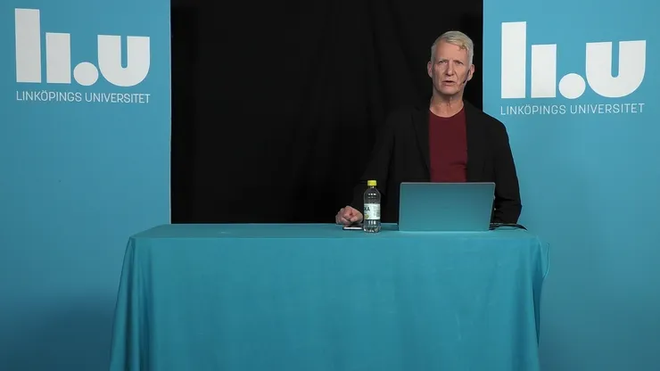 Forskare håller en digital föreläsning med en dator på bordet framför sig