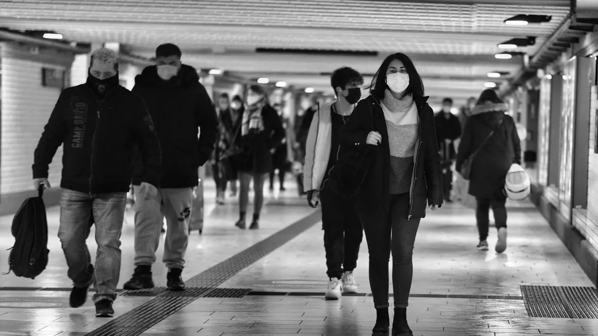 Människor i en tunnel, flera har munskydd.