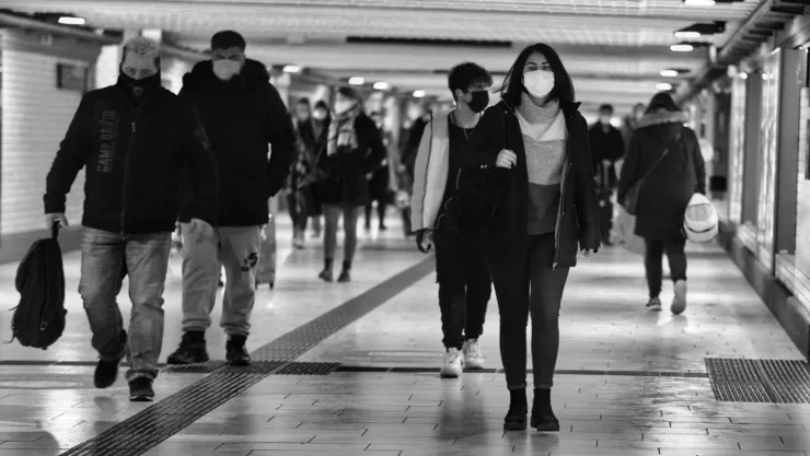 People in a tunnel, a lot of them use mask.