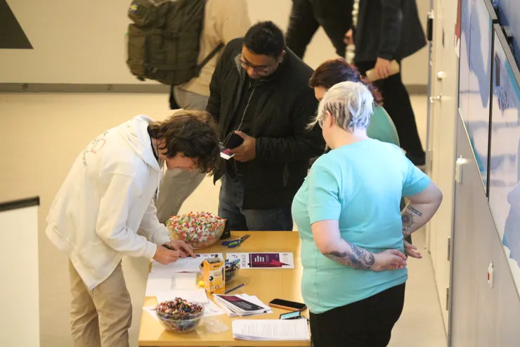 Visitor writing on paper at table