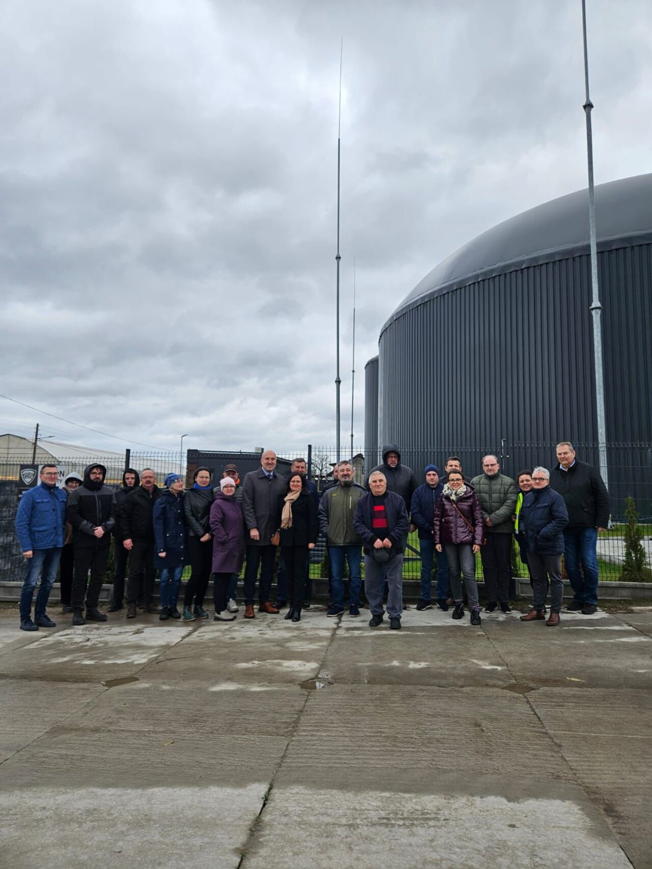 A group of people in front of a biogas plant
