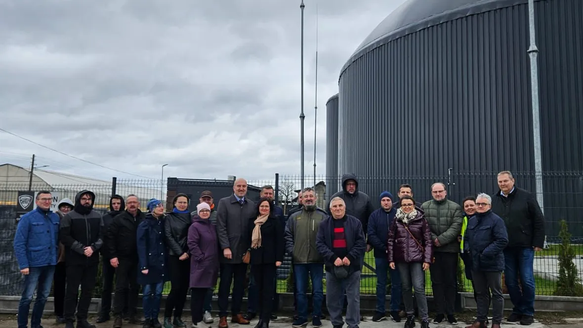 A group of people in front of a biogas plant