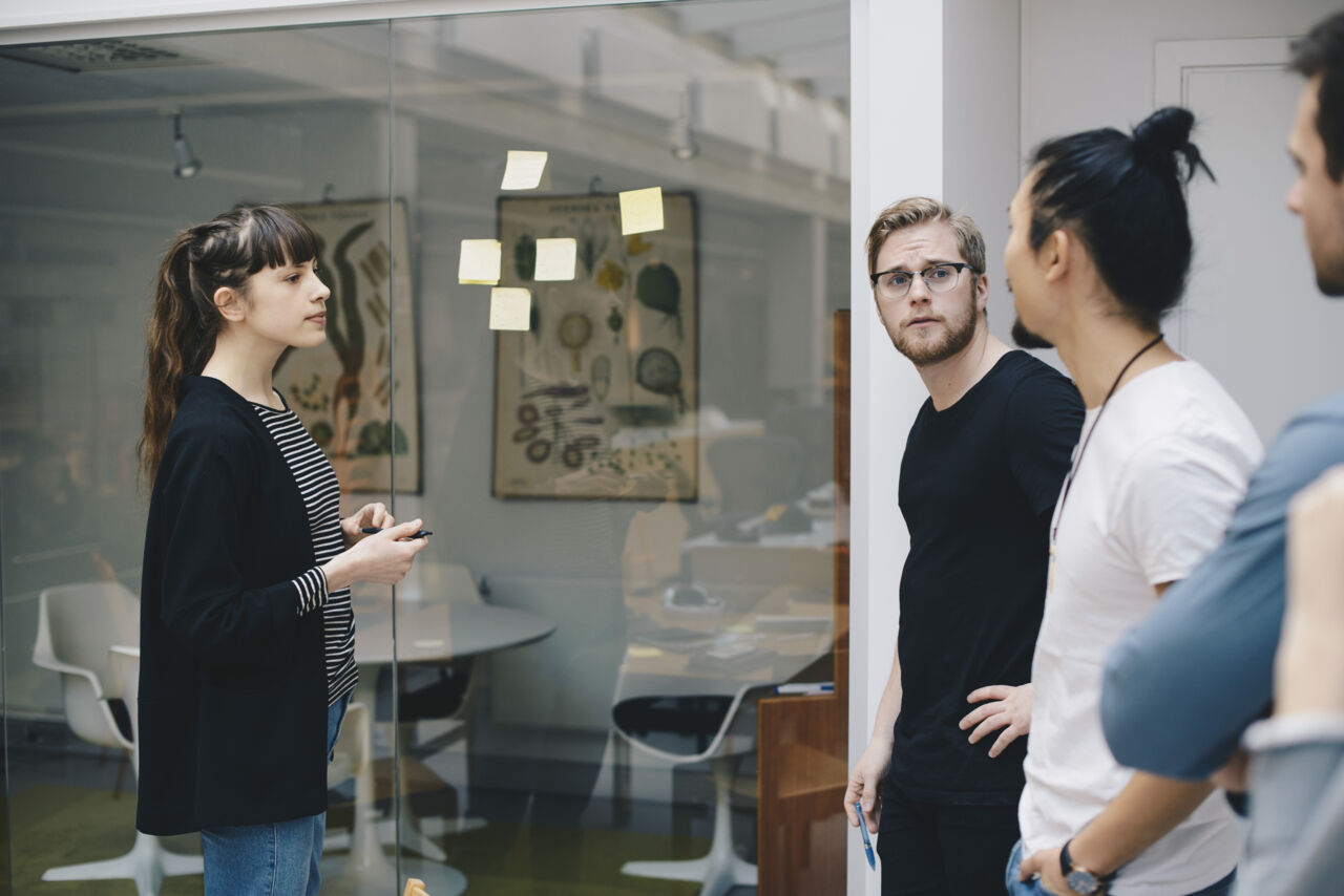 Tre personer står och pratar