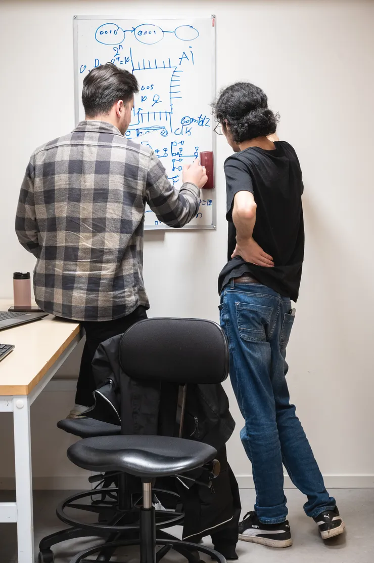 Studenter planerar sitt chip på en whiteboardtavla.