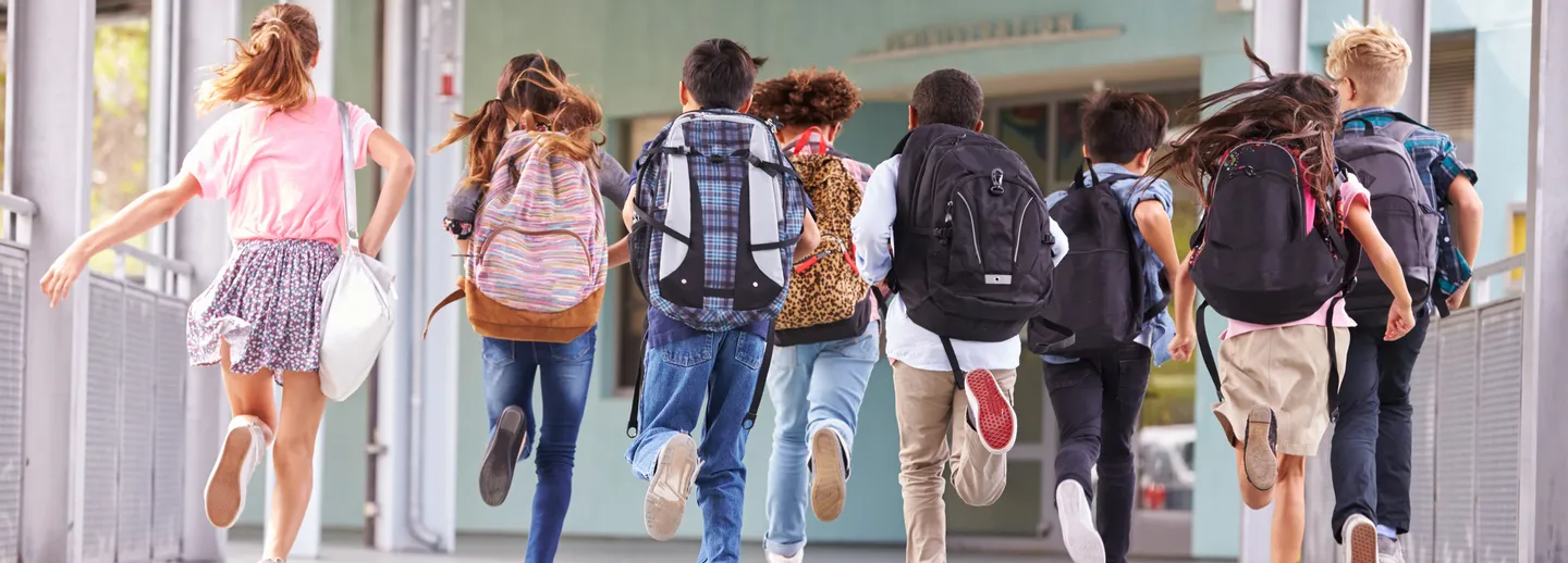 Skolbarn springer in till skolan.