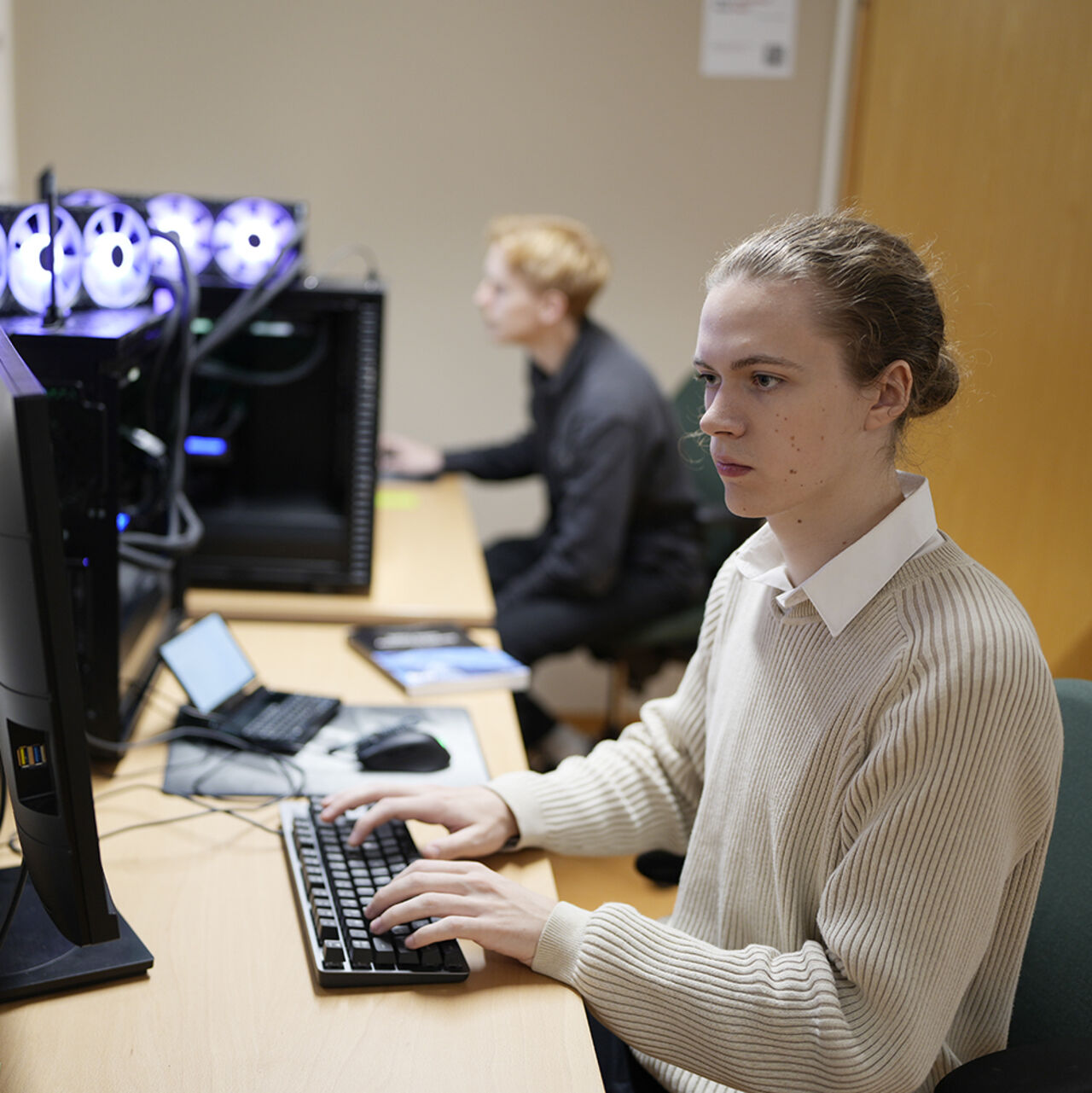 Two students working in front of each computer screen
