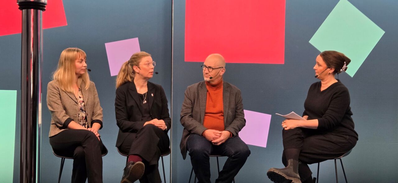 En grupp människor sitter runt ett bord i en studio.