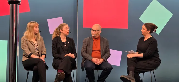 En grupp människor sitter runt ett bord i en studio.