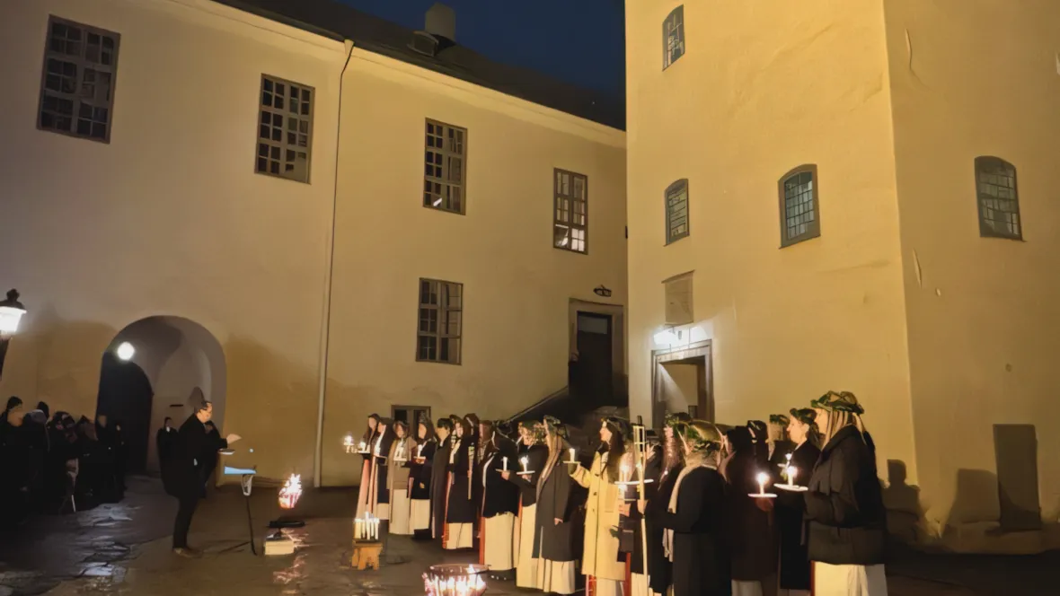 Luciakör sjunger vid borggård.