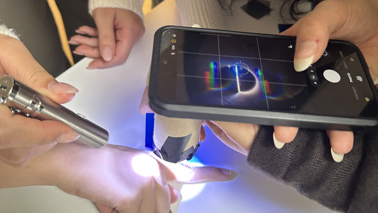 En mobil hålls över en hand