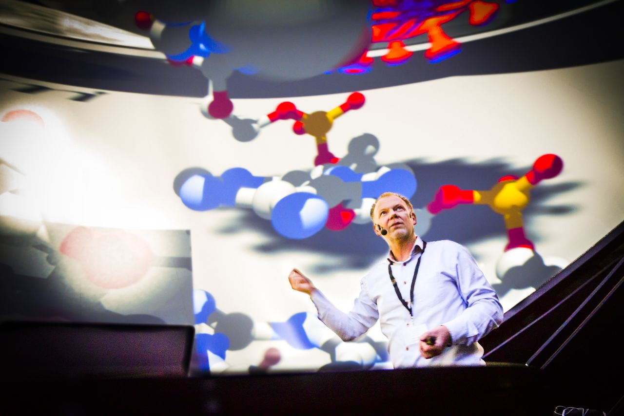 Man in front of pictures of colourful shapes