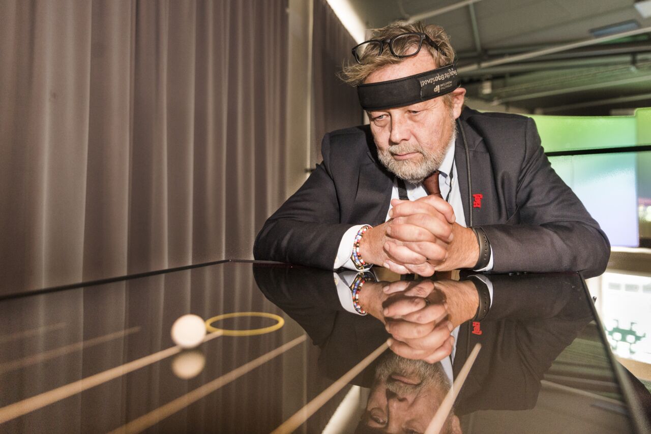 Man in headband looking at a small ball