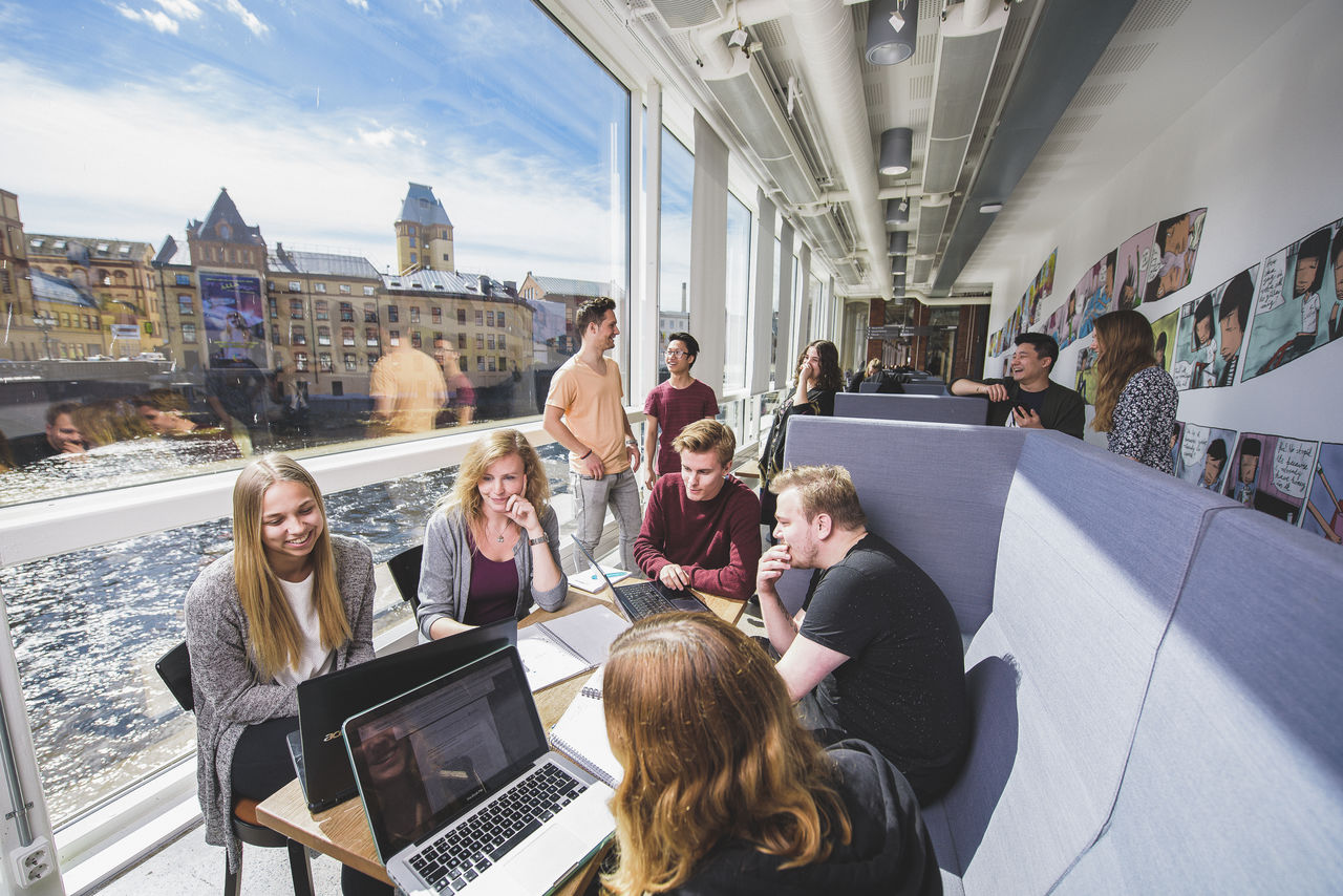 Studenter pluggar i Kåkenhus med vy över Strömmen i bakgrunden. 