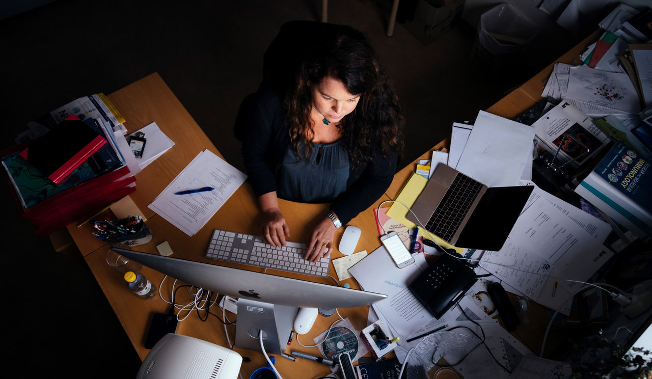 A person at a writing desk seen from above.