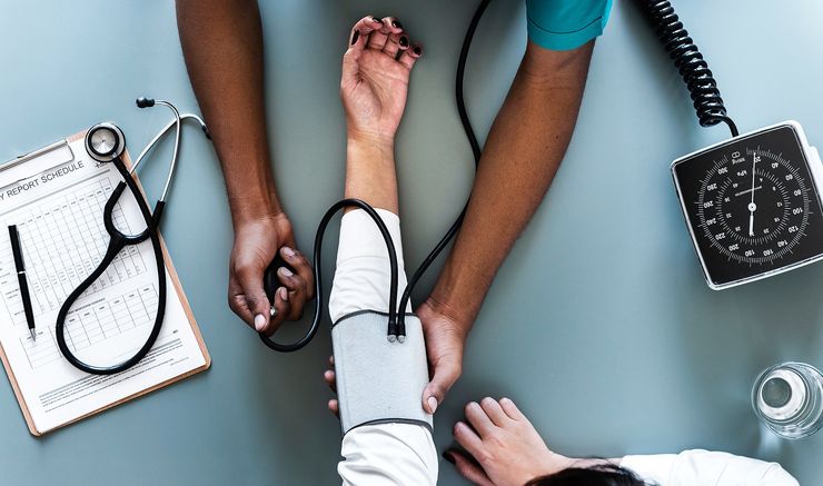 aerial view photography of person holding arm while pressing blood pressure machine