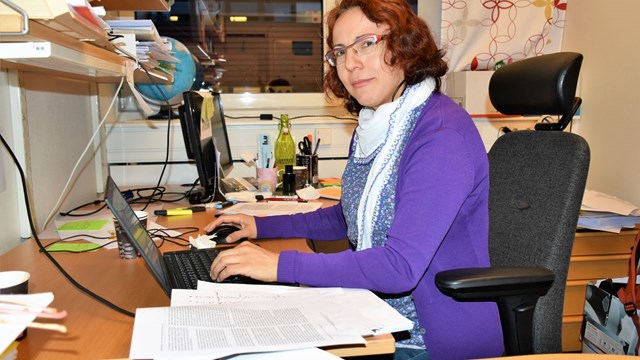 kvinna vid skrivbord med dator
