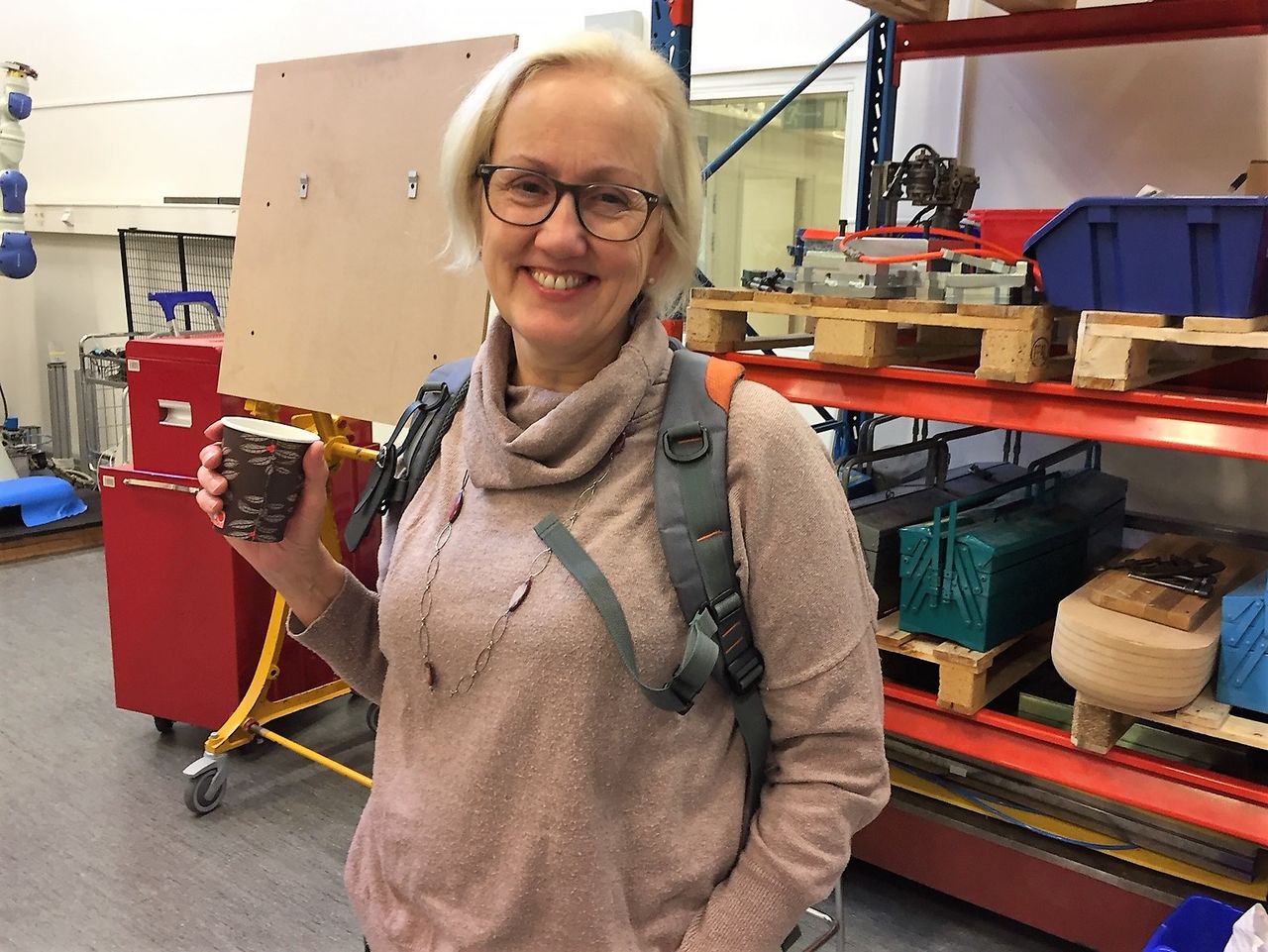 man visar skolbarn robot