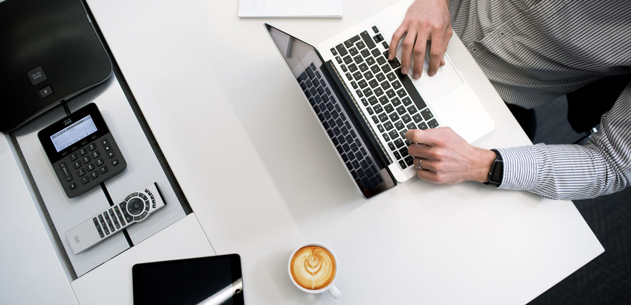 A pair of hands writing on a laptop.