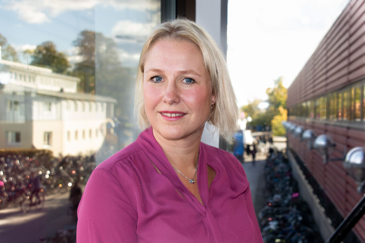 Kvinna framför fönster med utsikt över Campus Valla