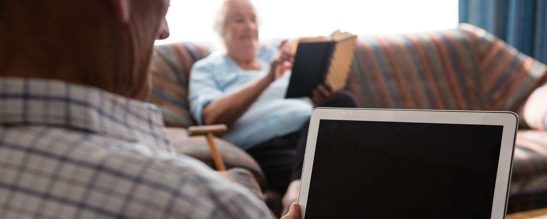 Äldre man med laptop på vårdhem