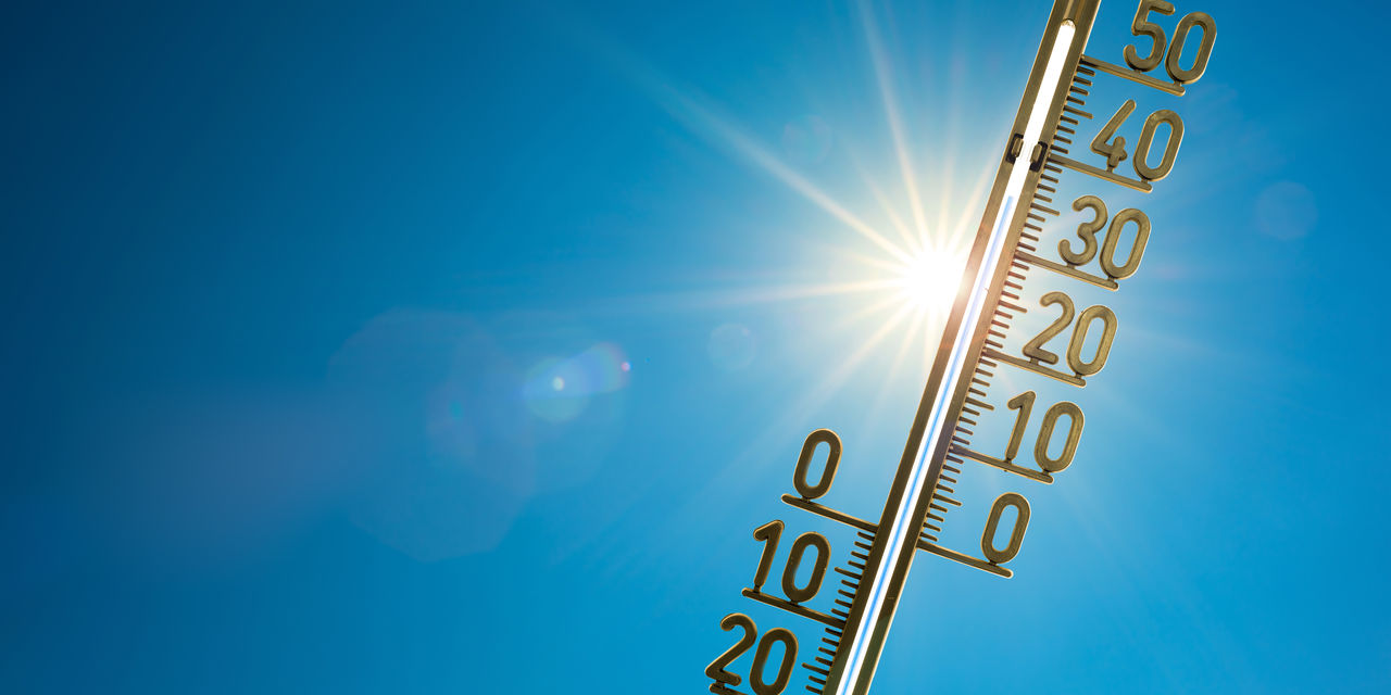 Thermometer with bright sun and blue sky