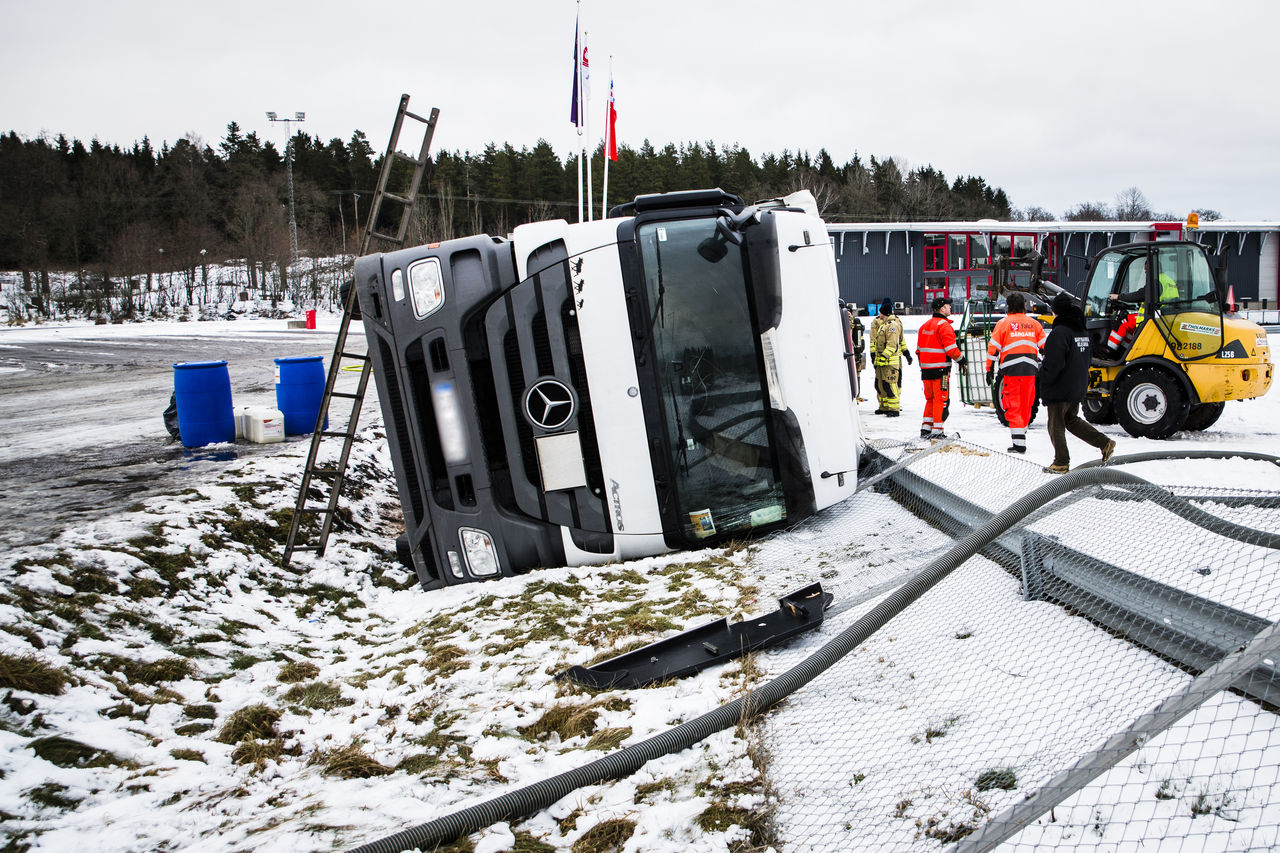 Lastbil som har vält i snöigt landskap.
