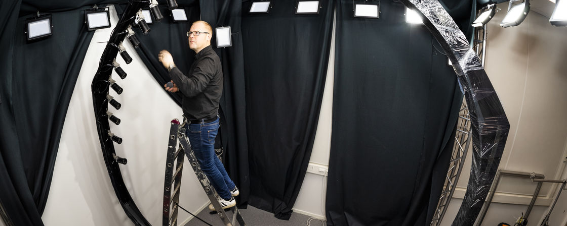 A man on a stepladder next to a circular rigg
