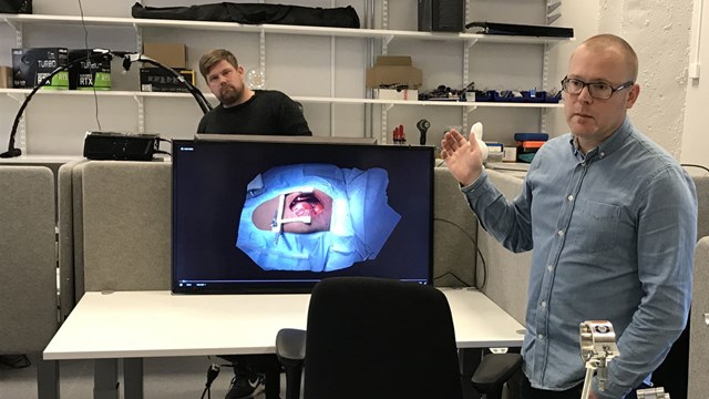 Jonas Unger i datorgrafiklaboratoriet, i bakgrunden ett bultande barnhjärta.