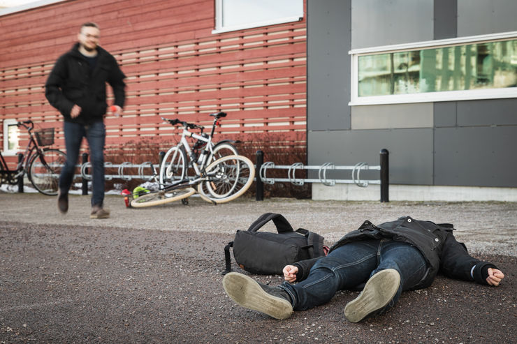 En person har fallit till marken och får hjälp av en annan.