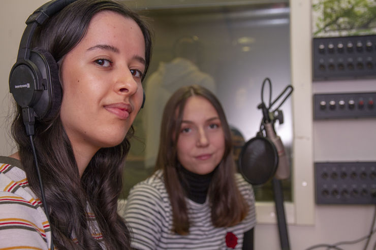 Två studenter vid kontrollbordet i en ljudstudio.