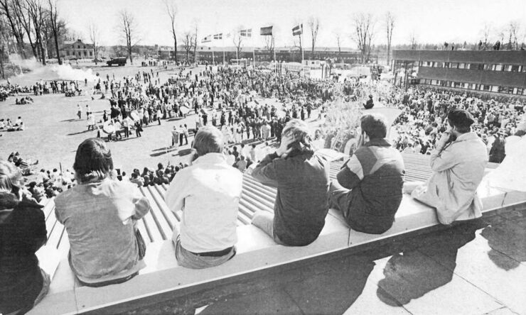 People sit outdoors, black and white picture.