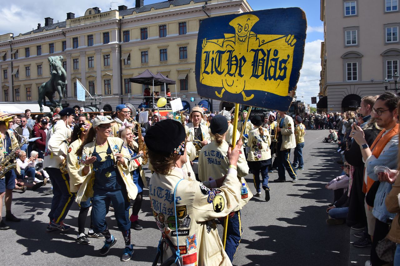 Orchestra in yellow jackets on a street.