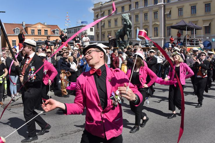 Studenter som spelar instrument och dansar i parad i LInköping city.